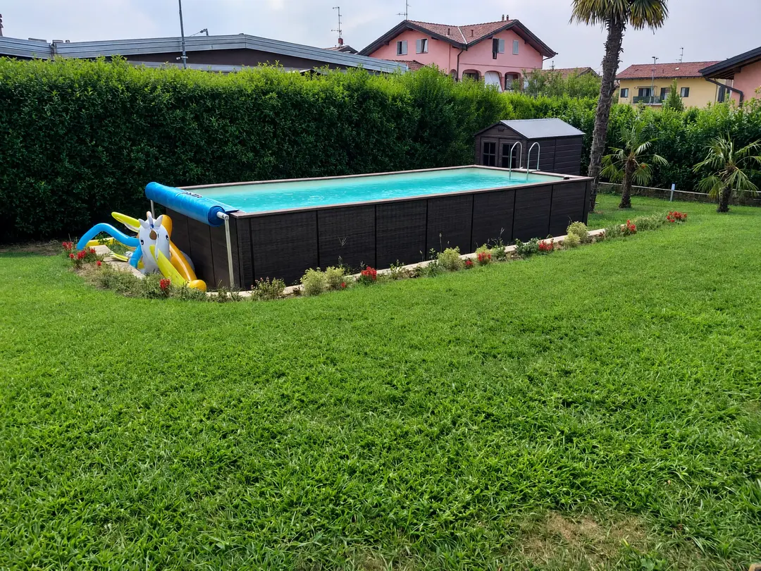 Piscina fuori terra con copertura estiva su rullo appoggiato a piantane